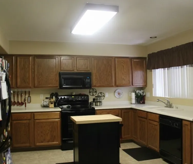 Kitchen with wooden cabinets and fluorescent ceiling light